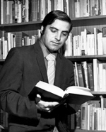 Dr. John Scigliano reading a book in a library